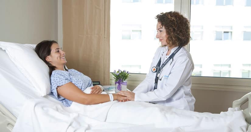 oncologue avec un patient souriant dans un lit d'hôpital