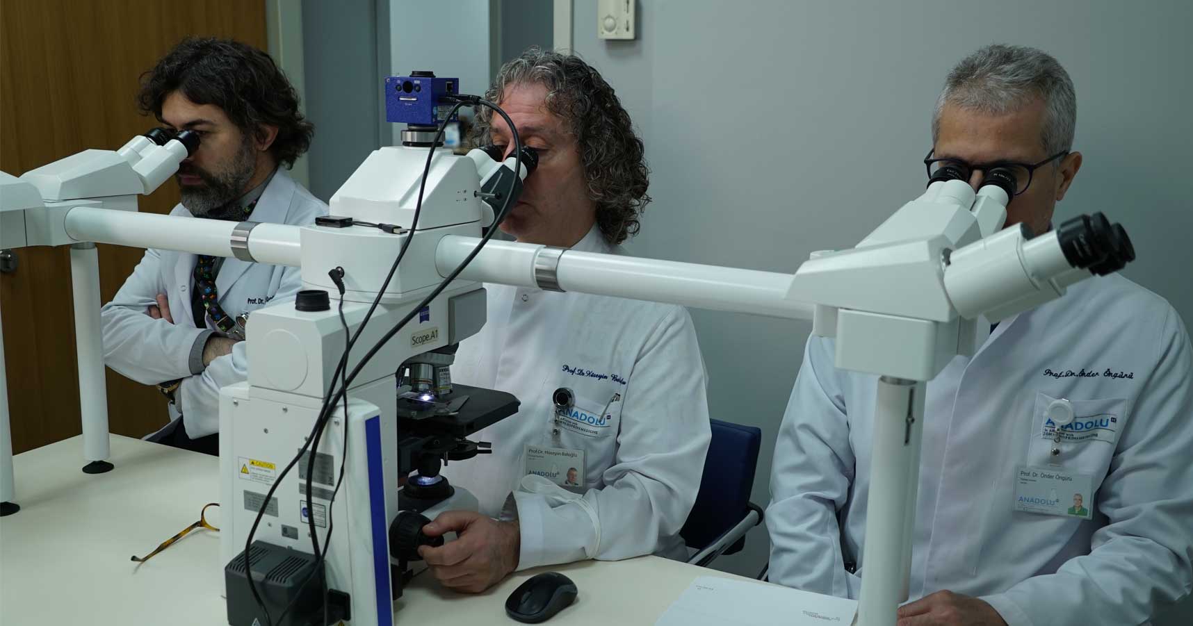 trois médecins utilisant des microscopes